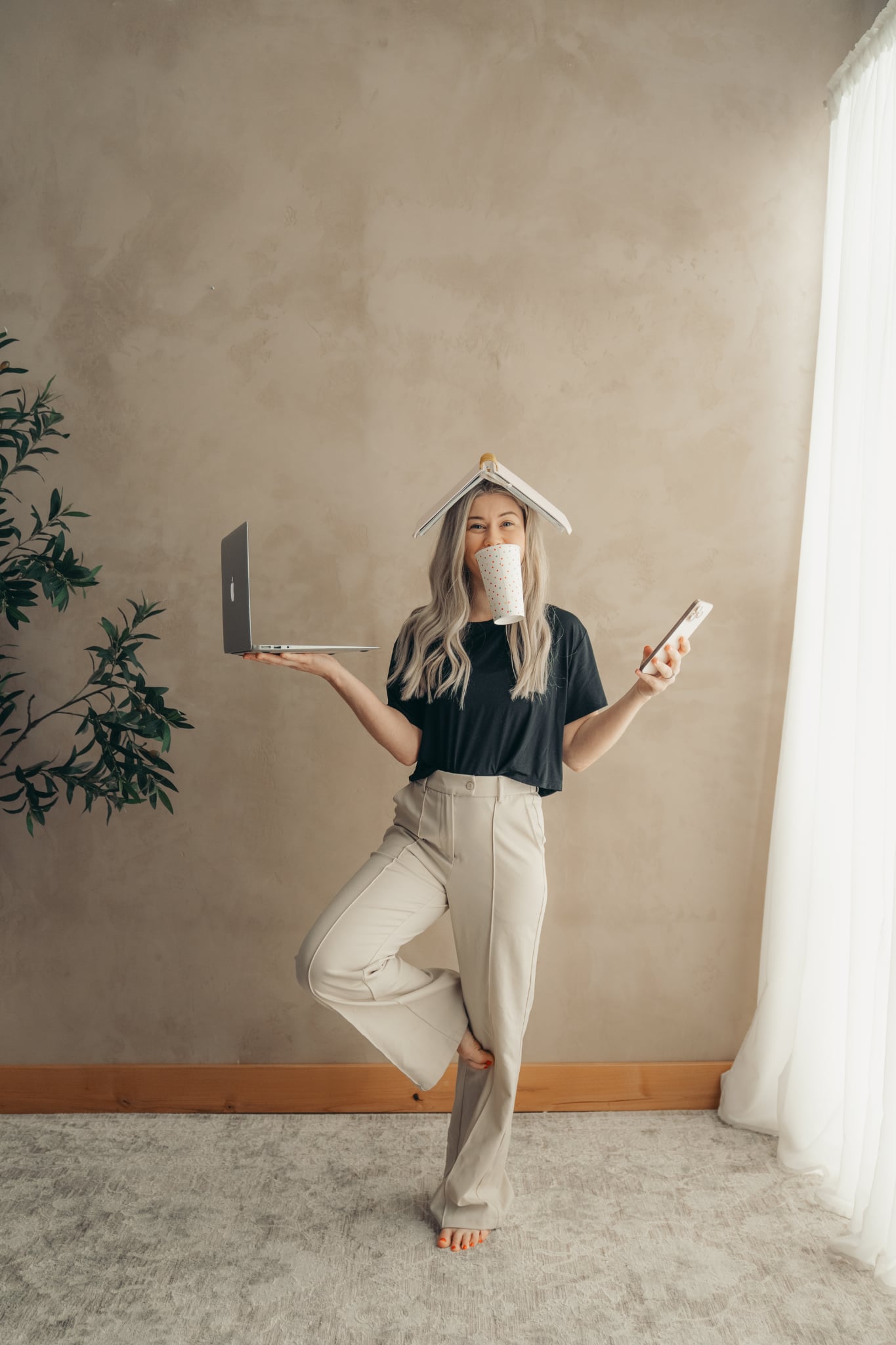 Kenzie Womack balancing laptop, phone, coffee and notebook